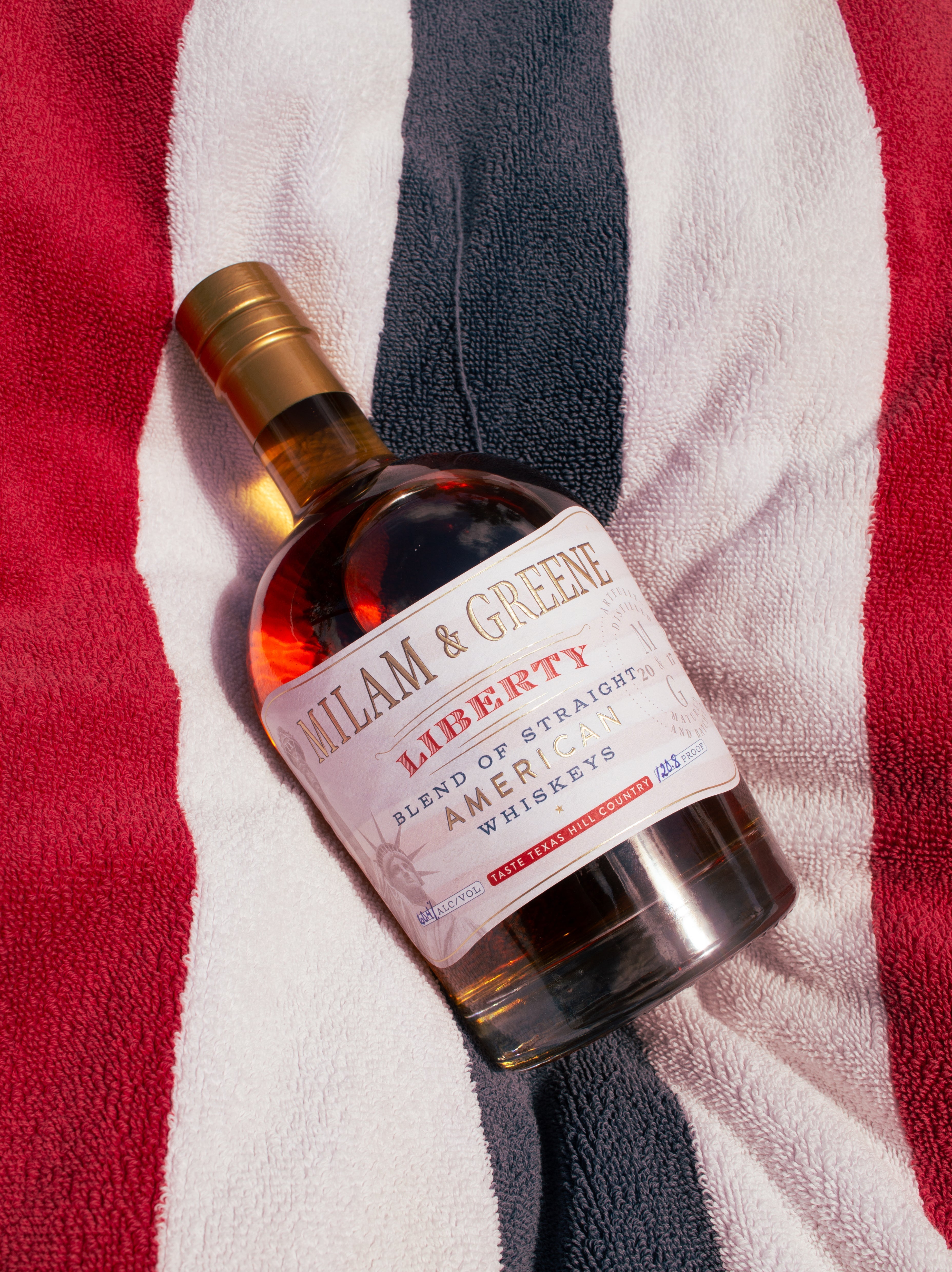 Bottle of William & Green Liberty Blend of Strained American Whiskeys on a striped towel background