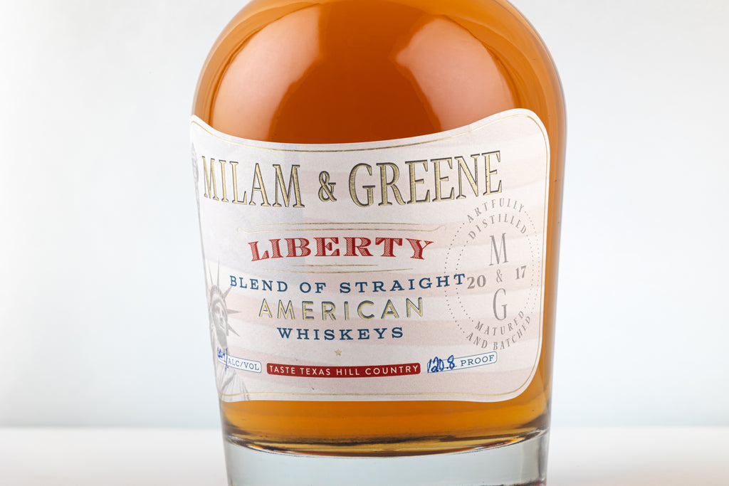 Bottle of Milam & Greene Liberty whiskey on a white background